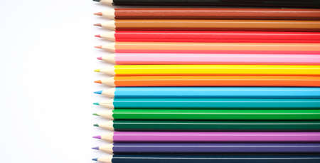 A set of colored pencils isolated on a white background in banner format. Place for text