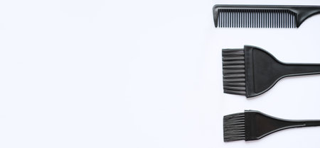 Top view, flat lay, hair coloring accessories, brushes and combs isolated on white background