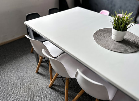 A white table with a white tablecloth and a white chairの写真素材