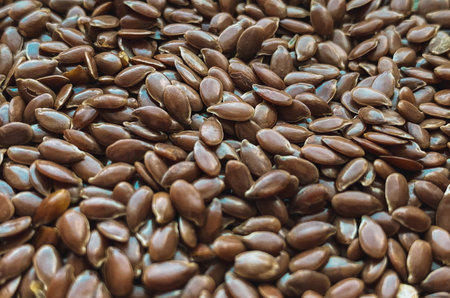 Macro close-up of raw brown flax seeds scattered in a natural pattern.