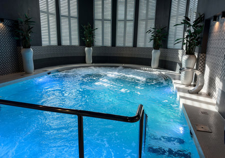 Luxury indoor swimming pool and spa with bubbling blue waterの写真素材