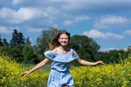Happy smiling teenage girl having fun in nature. Ukrainian girl on yellow and blue background. Field...