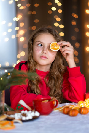 Teenage girl holds an orange slice in handの写真素材