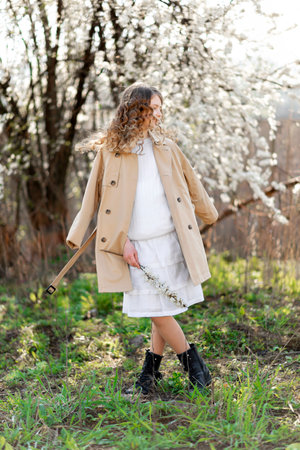 Young teenager girl walking in the garden at spring, enjoying warm sunny weatherの写真素材