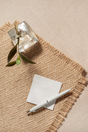 Minimalist aesthetic business or branding template. Blank paper sheet and pen on a beige textile background.の写真素材