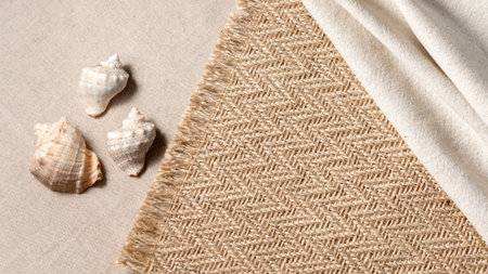 Minimal aesthetic neutral summer vacation concept with sea shells and jute rug on a beige background, copy spaceの写真素材