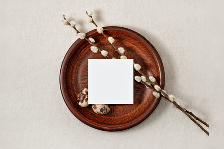 Rustic aesthetic minimal Easter greeting card template, blank paper sheet, quail eggs, pussy willow branches on a plate on neutral beige background, copy spaceの写真素材
