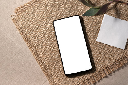 Aesthetic minimalist business branding template, mobile phone with blank screen mock up on a neutral beige background, copy spaceの写真素材