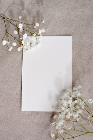 Minimal aesthetic greeting card, letter template, plank paper card and flowers on a neutral beige linen background, copy spaceの写真素材