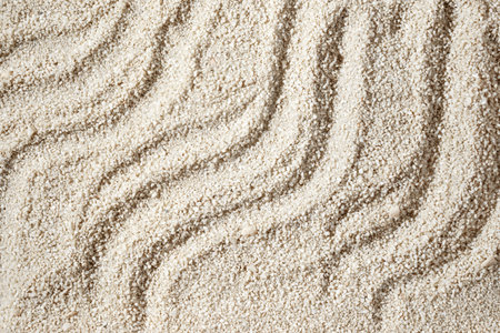 Aesthetic minimalist summer vacation background, waves ornament on a neutral beige beach sand texture, copy spaceの写真素材