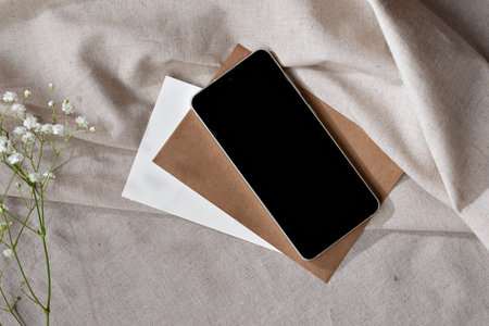 Minimalist aesthetic home office workspace, mobile phone and paper cards on a neutral beige textile background, elegant business brand template, copy spaceの写真素材