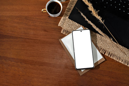 Mobile phone with empty screen mockup, laptop, cup of coffee on a wooden table background, minimalist aesthetic business branding template, flatlay with copy spaceの写真素材