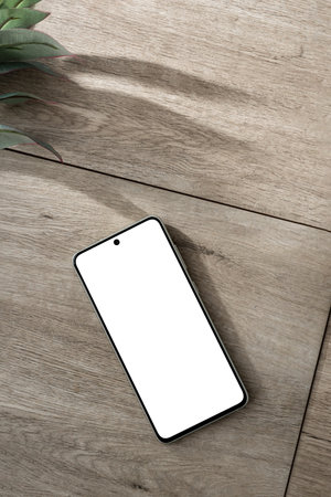 Blank screen of mobile phone, green plant with sun light shadows on a neutral beige wooden desk background, mock up with copy space, aesthetic business branding, social media templateの写真素材