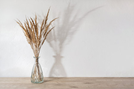 Minimalist aesthetic neutral home room interior design template, white concrete wall, neutral beige wooden table with vase and meadow flower bouquet, empty background with copy spaceの写真素材