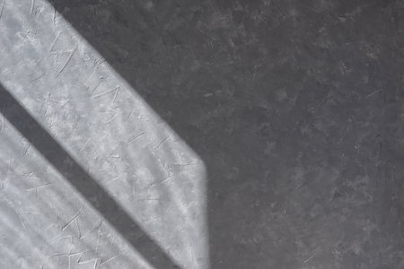 Aesthetic geometric sunlight shadow on a gray concrete textured wall, empty template for home room interior product, background for branding design showcase, copy spaceの写真素材