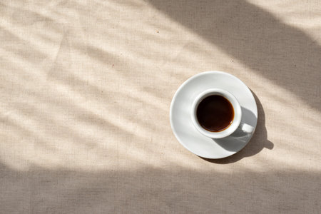 Minimalist neutral aesthetic background, coffee cup on a beige linen backdrop with abstract natural sunlight shadows, good morning concept, copy spaceの写真素材