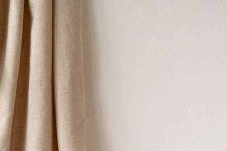 Empty white plaster wall and a beige linen curtain background, aesthetic neutral interior design template, mockup with copy spaceの写真素材