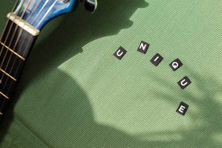 Unique word and guitar on a green background with abstract sunlight shadow. Lifestyle concept of...