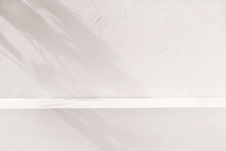 Brand product showcase template, blank neutral light beige podium stage with aesthetic lifestyle floral sun light shadows, white textured concrete wall and shelf background.の写真素材