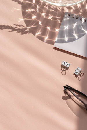 Minimalist aesthetic feminine business brand backdrop, stationery on a peach background with abstract sunlight shadowの写真素材