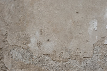 Authentic old ancient cracked neutral beige stacco plaster wall texture. Ancient architecture building exterior backgroundの写真素材