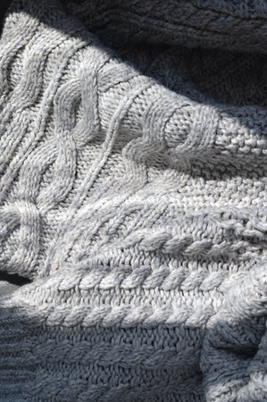 Crumpled neutral gray woolen knitted sweater with cable stitch ornament and natural sunlight shadow, lifestyle fall, winter background, business branding template.の写真素材
