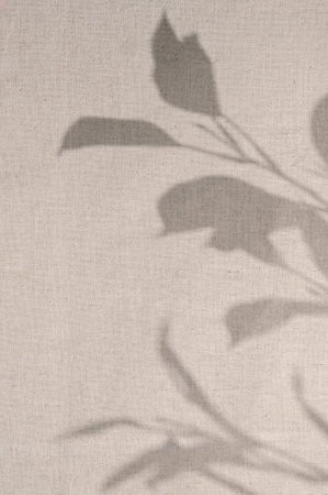 Elegant floral natural sun light shadow on linen neutral beige curtain background. Aesthetic...
