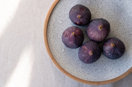 Gigs on plate, on beige linen tablecloth with natural sunlight shadows, flat lay, copy space.の写真素材