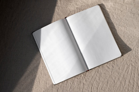 Open notebook mockup with empty paper sheets on neutral beige linen texture background with...
