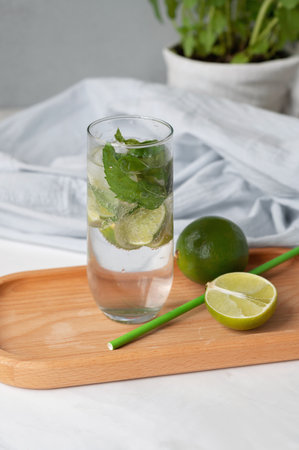 Homemade mojito cocktail drink, limes, drinking straw on kitchen table, summer home cooking.の写真素材