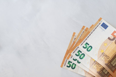 Minimal business background with paper euro currency banknote fragments on marble gray neutral...