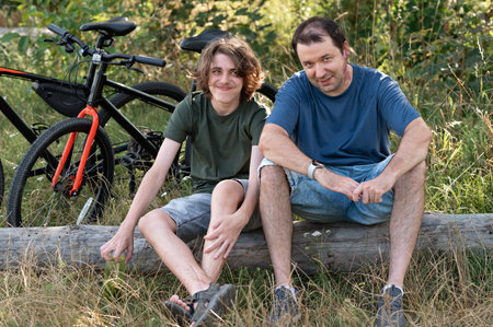 Father and son resting in nature outdoor while cycling in countryside.の写真素材