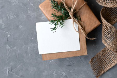 Christmas holiday greeting card design template, empty white paper card, envelope and gift box on gray background, rustic style.の写真素材