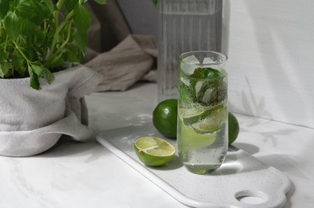 Homemade summer fresh drink with lime and mint, glass with mojito cocktail on table.の写真素材