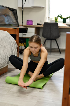 Authentic lifestyle home fitness concept, teenager girl healthy sport routine, woman do yoga at home.の写真素材