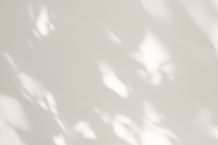 Soft abstract spotty sunlight shadows on neutral light beige plaster wall background, minimal aesthetic backdrop for business branding and social media designの写真素材