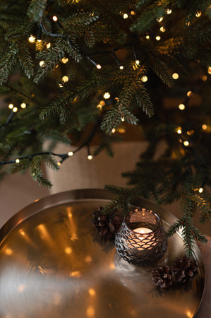 Blurred Christmas tree lights, golden tray and candle. Aesthetic winter holiday background.の写真素材