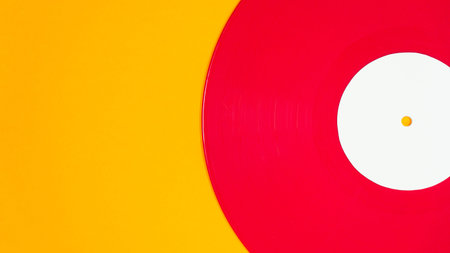 Close flat lay composition of red vinyl record on yellow backdrop. Retro audio concept with copy...