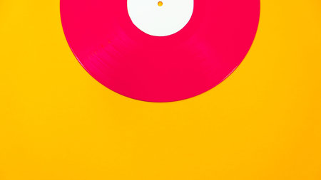 Red vinyl record partial visible on bright background. Modern retro music flat lay with copy space.