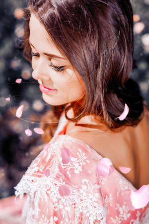 fabulous, young girl with beautiful hair in a vintage pink dress in the gardenの写真素材