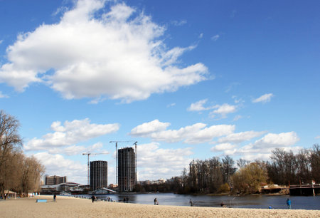 KYIV / UKRAINE - April 1, 2017 - Fishermen on the Dnieper in Kiev, Ukraine. A view of the city in the distance, under a spring cloudy sky.の写真素材