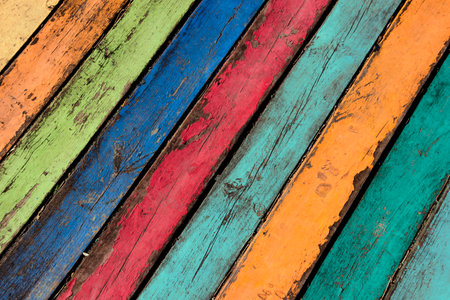 Wood planks painted with paint cracked by a rustic background. Wooden texture in multicolor paint. Color wood background textures. Color wood background textures. Blue, green, yellow,orange,pinkの写真素材