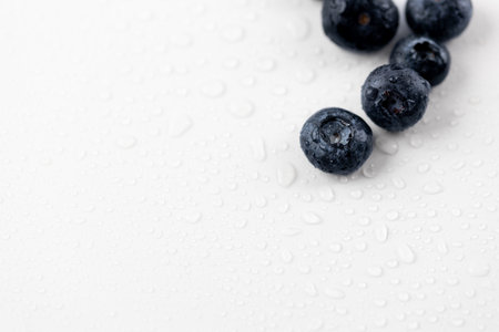 top shot close up on a white photo background there are a lot of ripe big blueberries among drops of water healthy vitamins seasonal summer fruits vitamin Cの写真素材