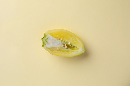 close-up photograph of an object on a light yellow background lies freshly washed light yellow bell pepper with stem cut in half healthy vegetarian nutrition many useful vitaminsの写真素材