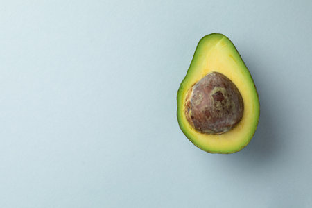 close-up photograph of an object on a light blue background lies half a green round ripe fresh...