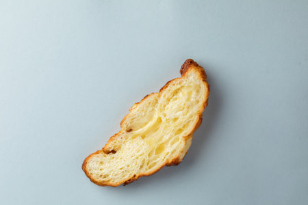 close-up photograph of an object on a light blue background lies a sliced piece of ruddy white bread related pastriesの写真素材