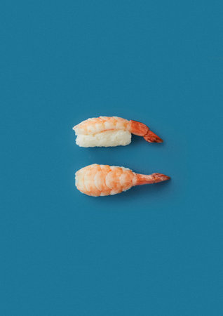 top shot on a blue background lies a set with two sashimi with king prawns professional presentation of Japanese cuisineの写真素材