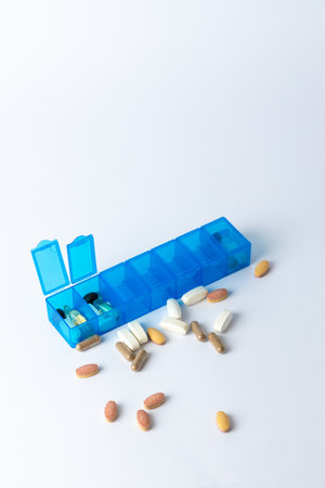 white background two bright blue pill boxes with a couple of open lids for taking pills, health...