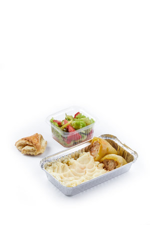 white background disposable plastic and foil tableware mashed potatoes and stuffed peppers vegetable salad daily allowance one-time mealsの写真素材