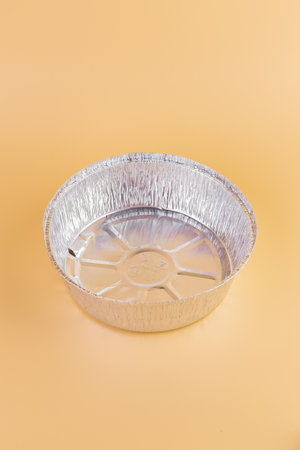 top shot close-up on a soft yellow background lie new kitchen foil round baking molds modern technologies cleanliness in the kitchen practical useの写真素材